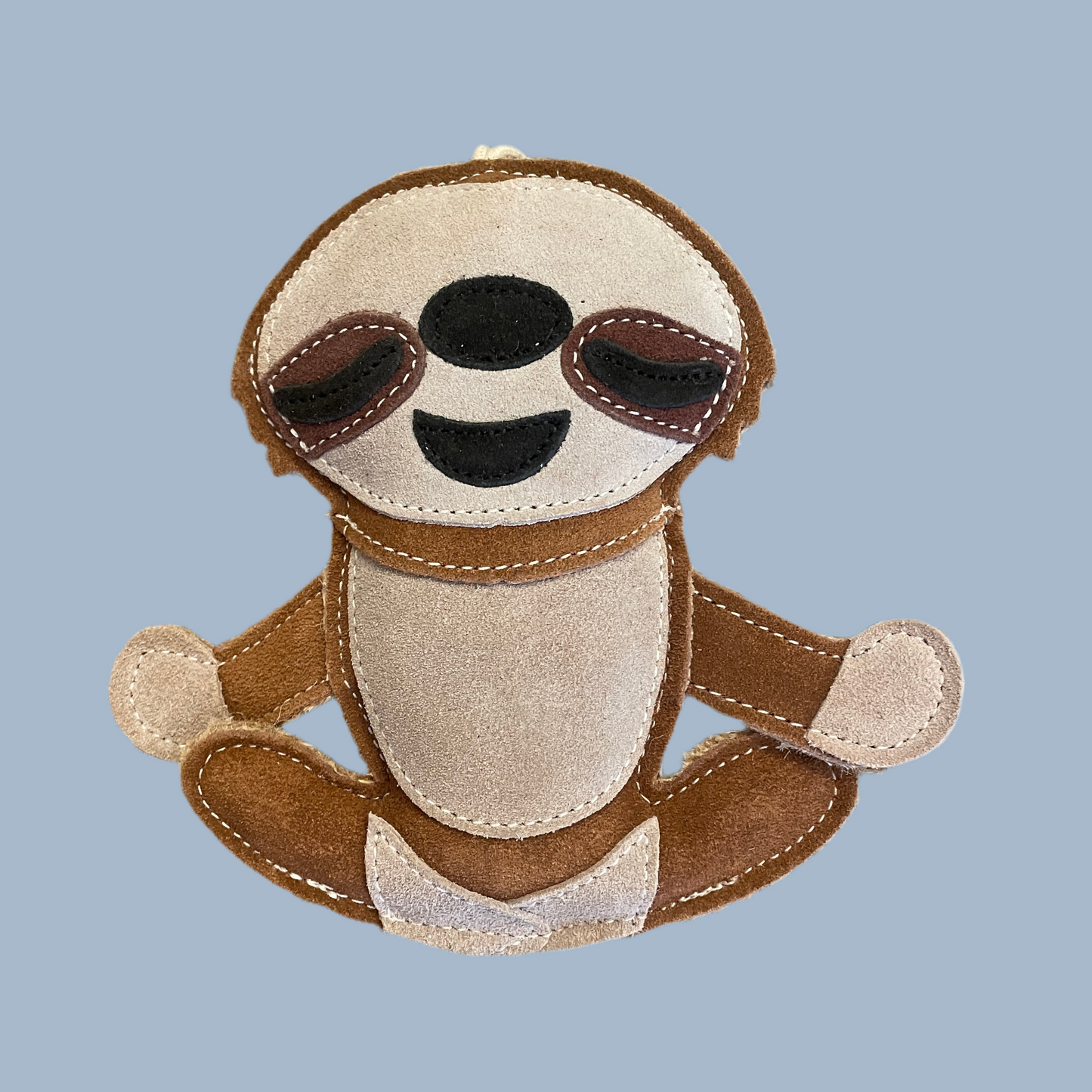 Suede toy sloth with sunglasses on a light blue background